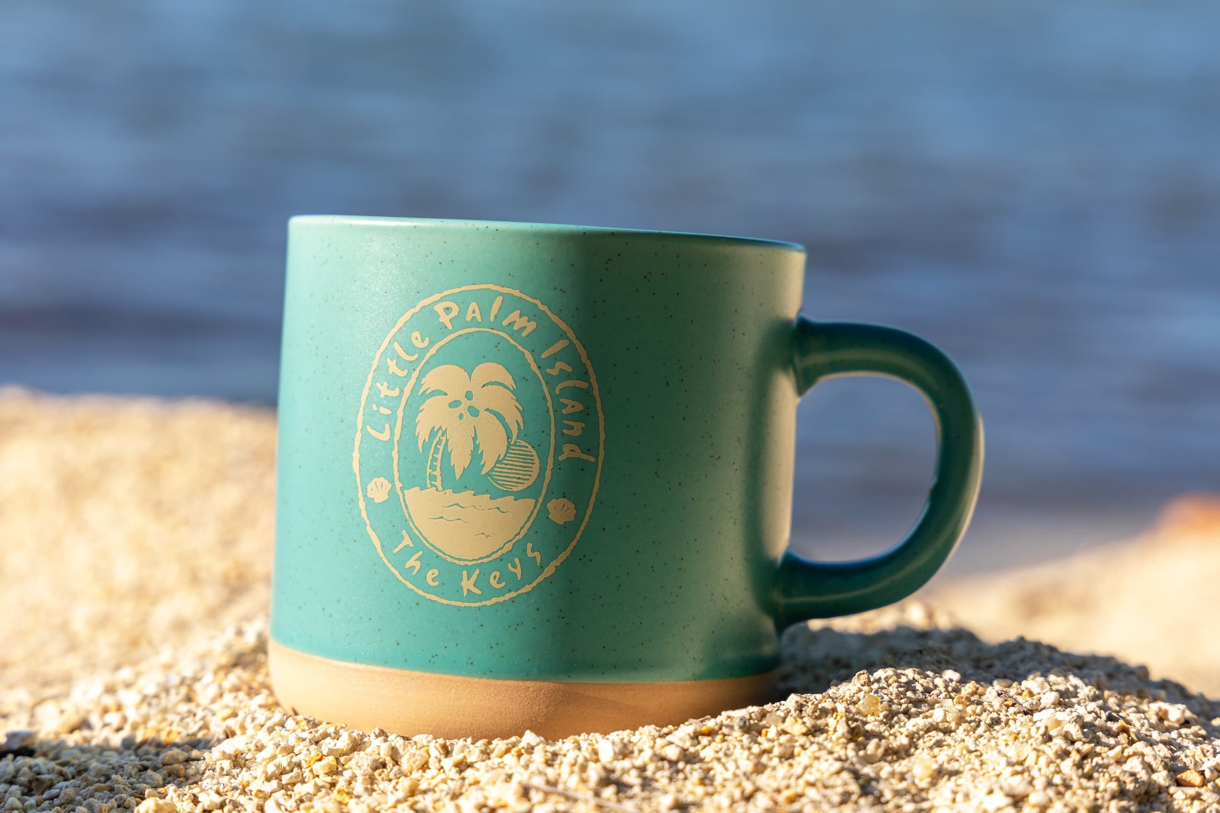 A green Little Palm Island branded mug