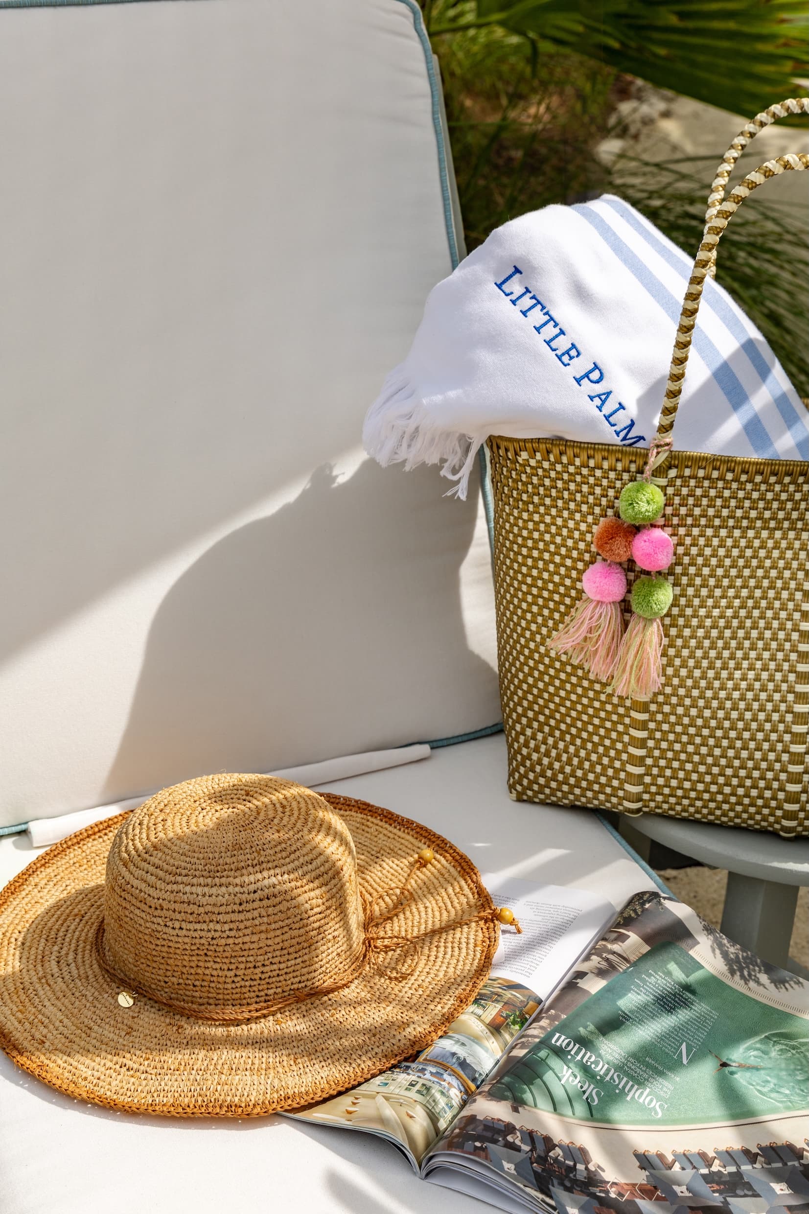 A Bag and hat from Little Palm Island on a beach chair