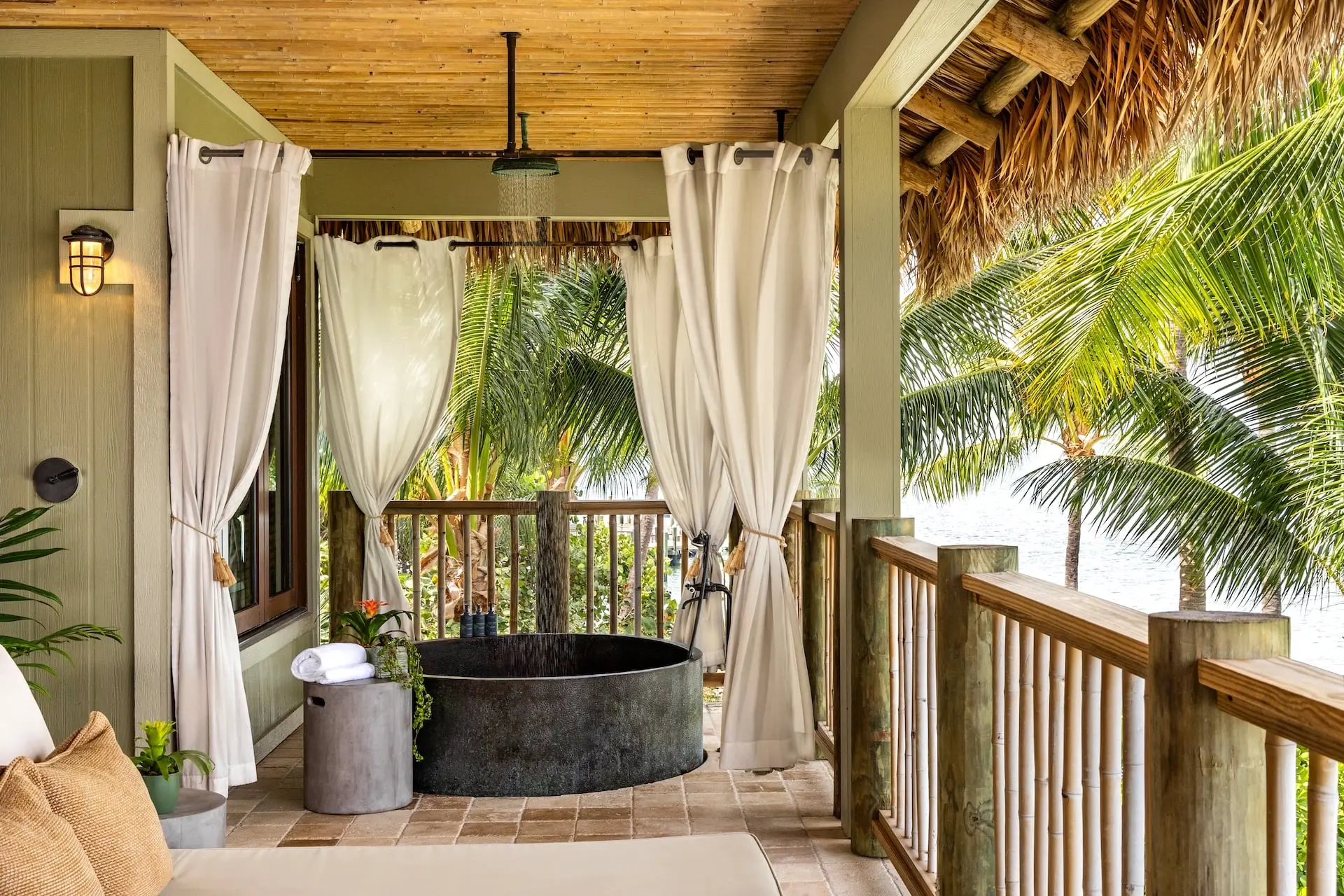A balcony with a tub off of a suite at Little Palm Island