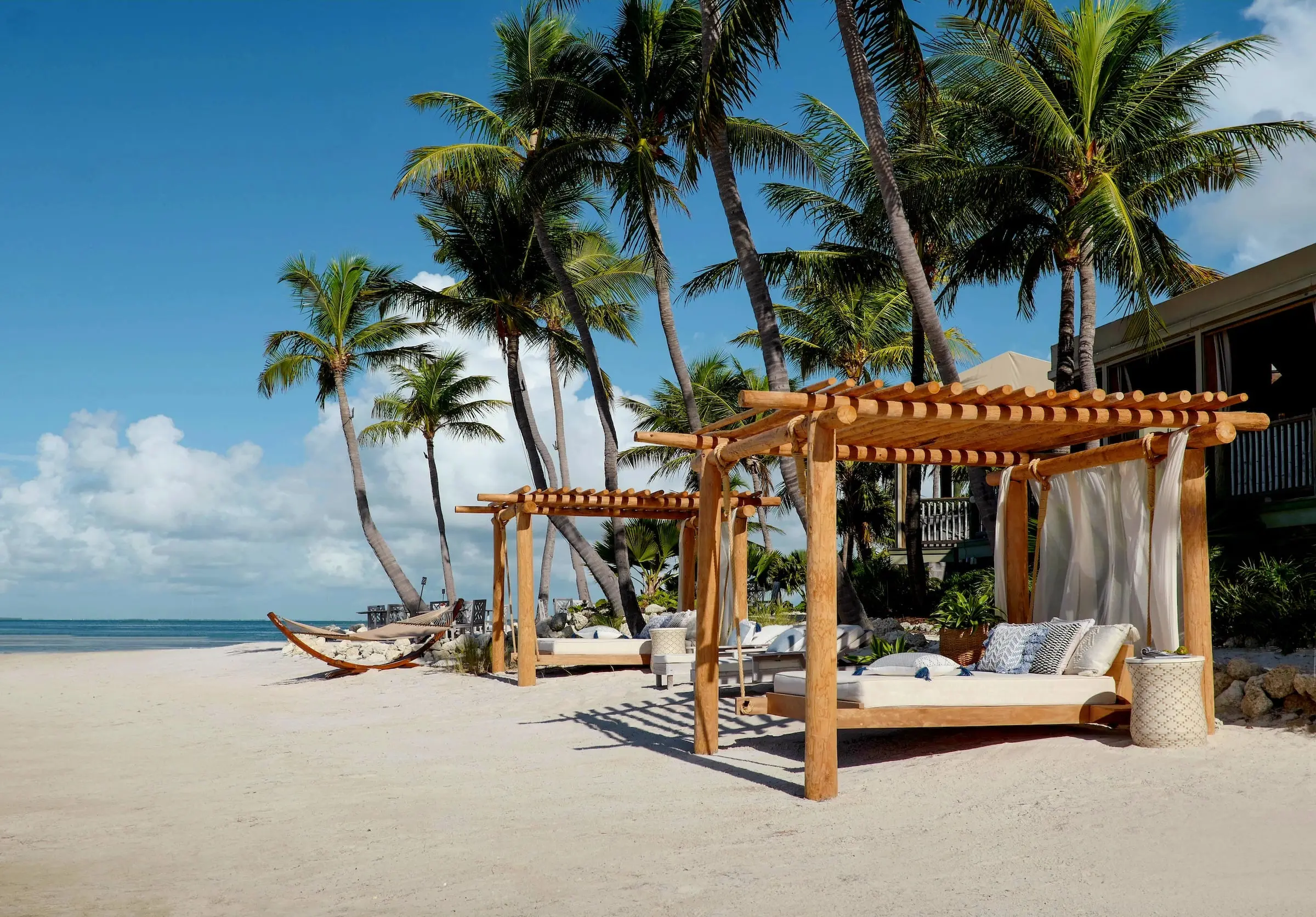 A cabana and a hammock on the beach waiting for a guest at Little Palm Island Resort