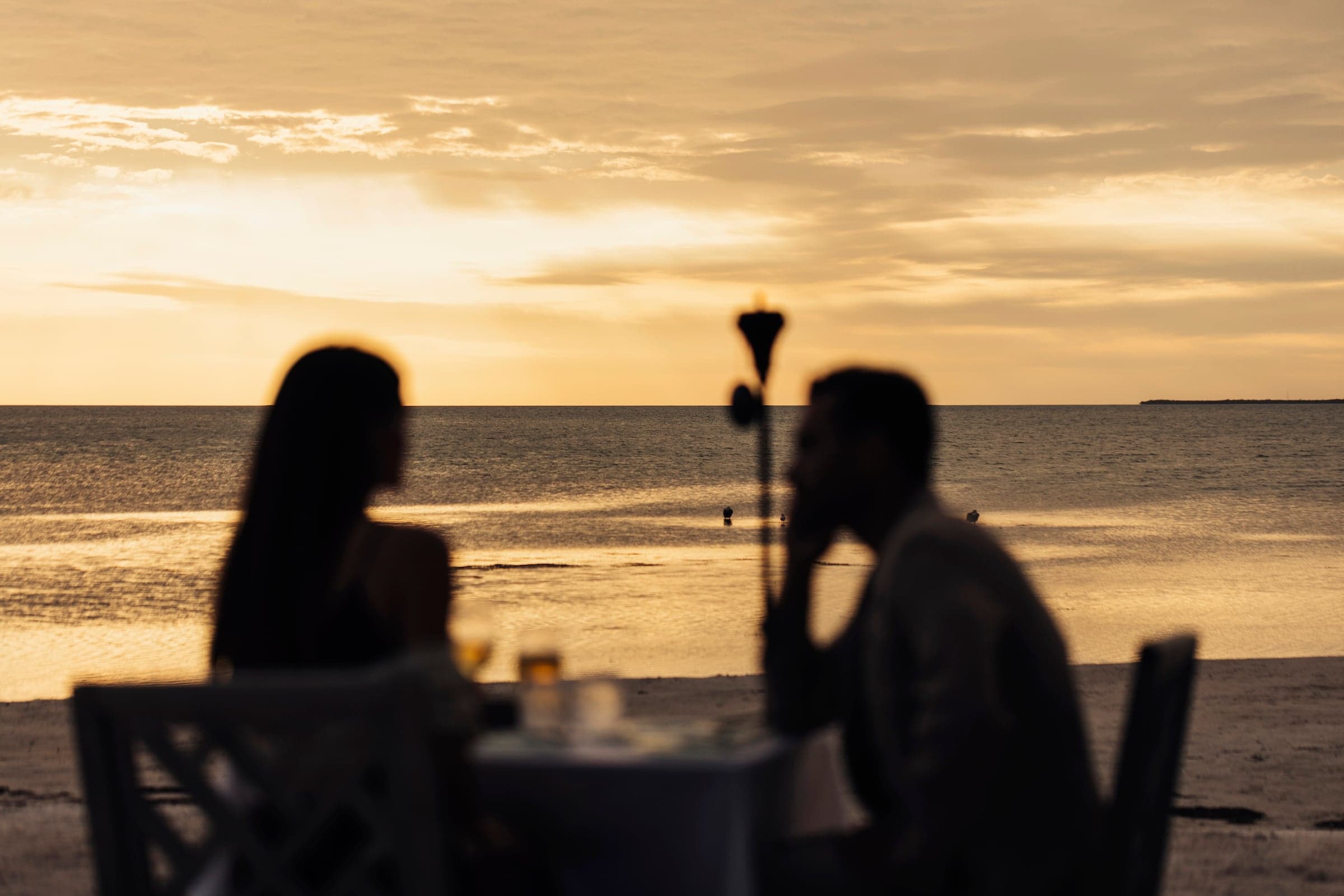 A couple on the beach having a private meal at Little Palm Island Resort
