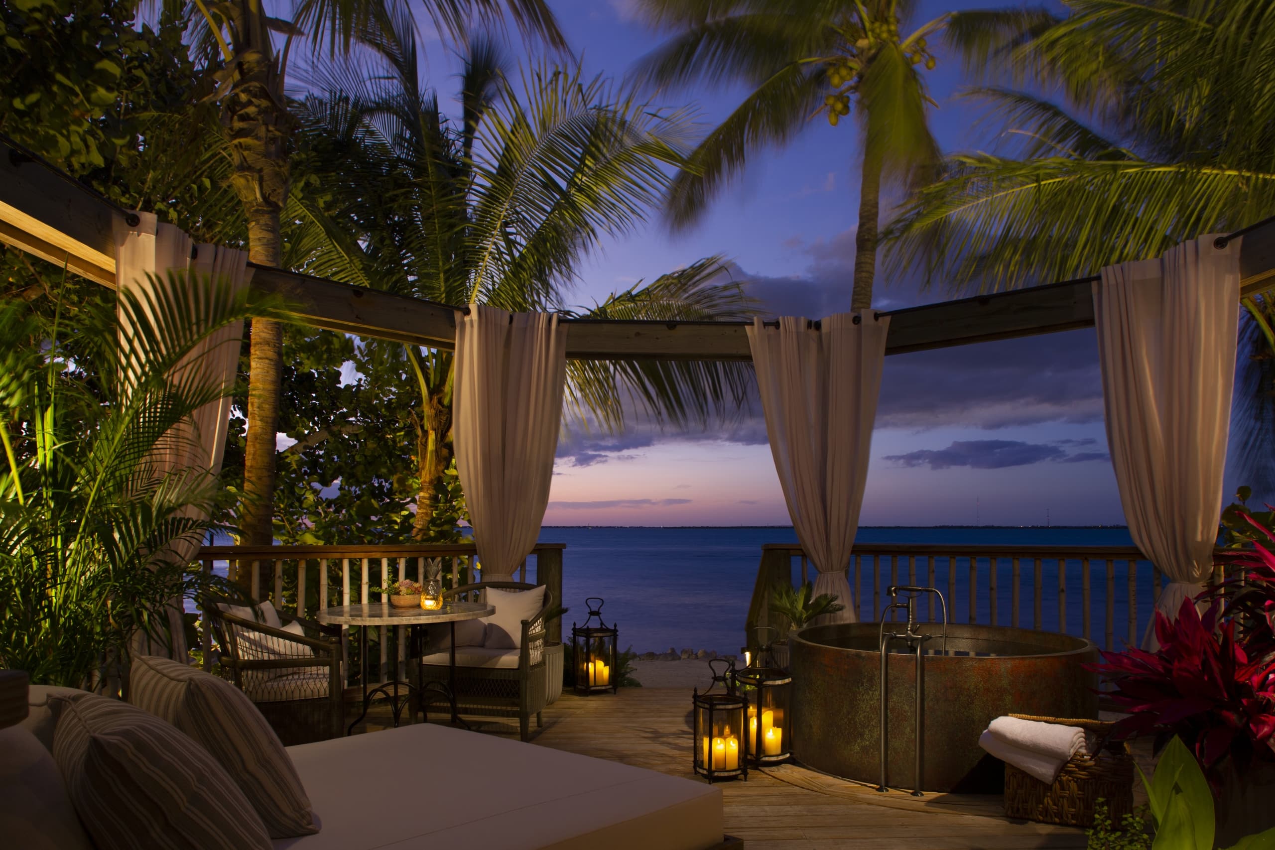 A patio at night with a soaker tub at Little Palm Island
