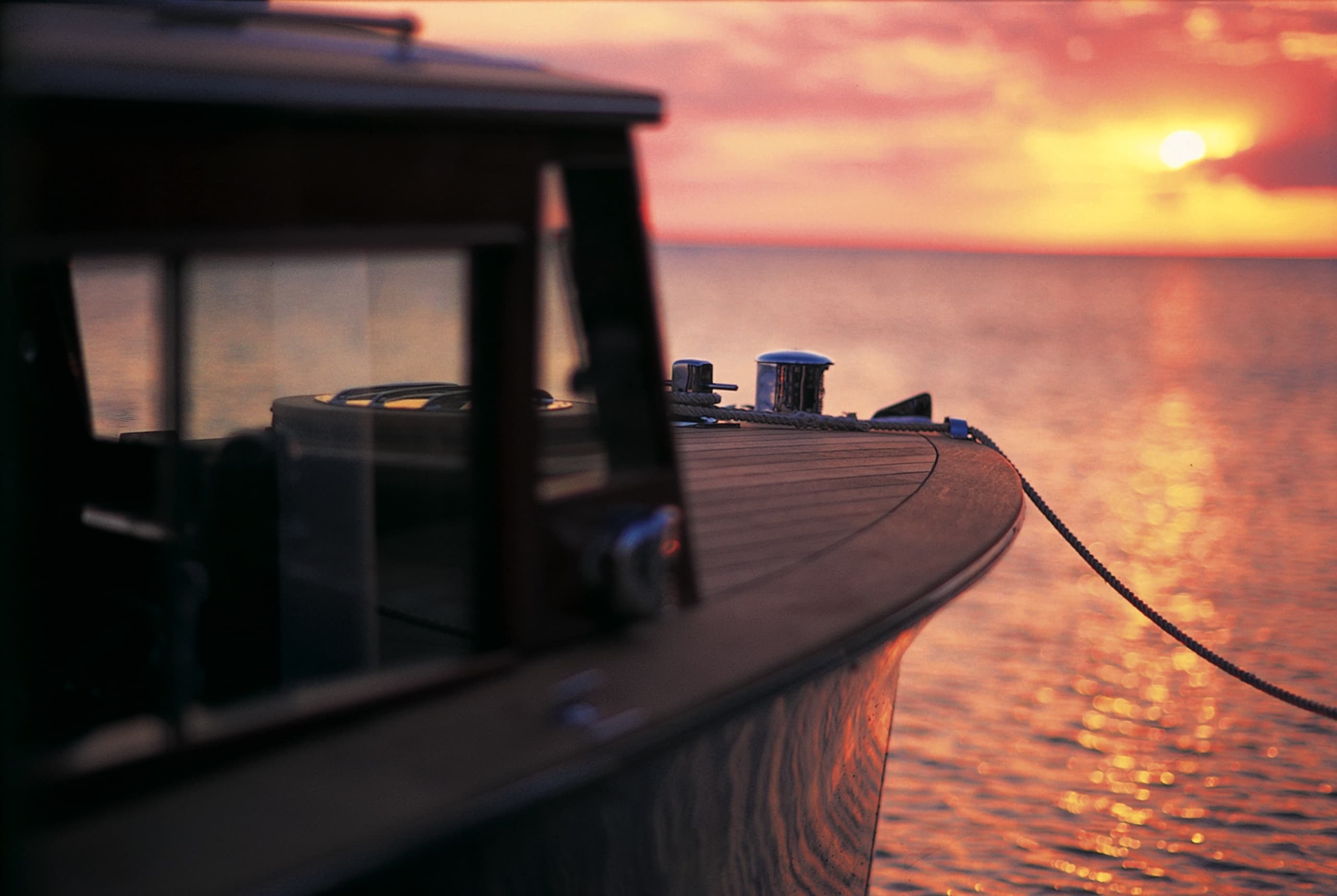 A boat tied to the dock at Little Palm Island at sunset.