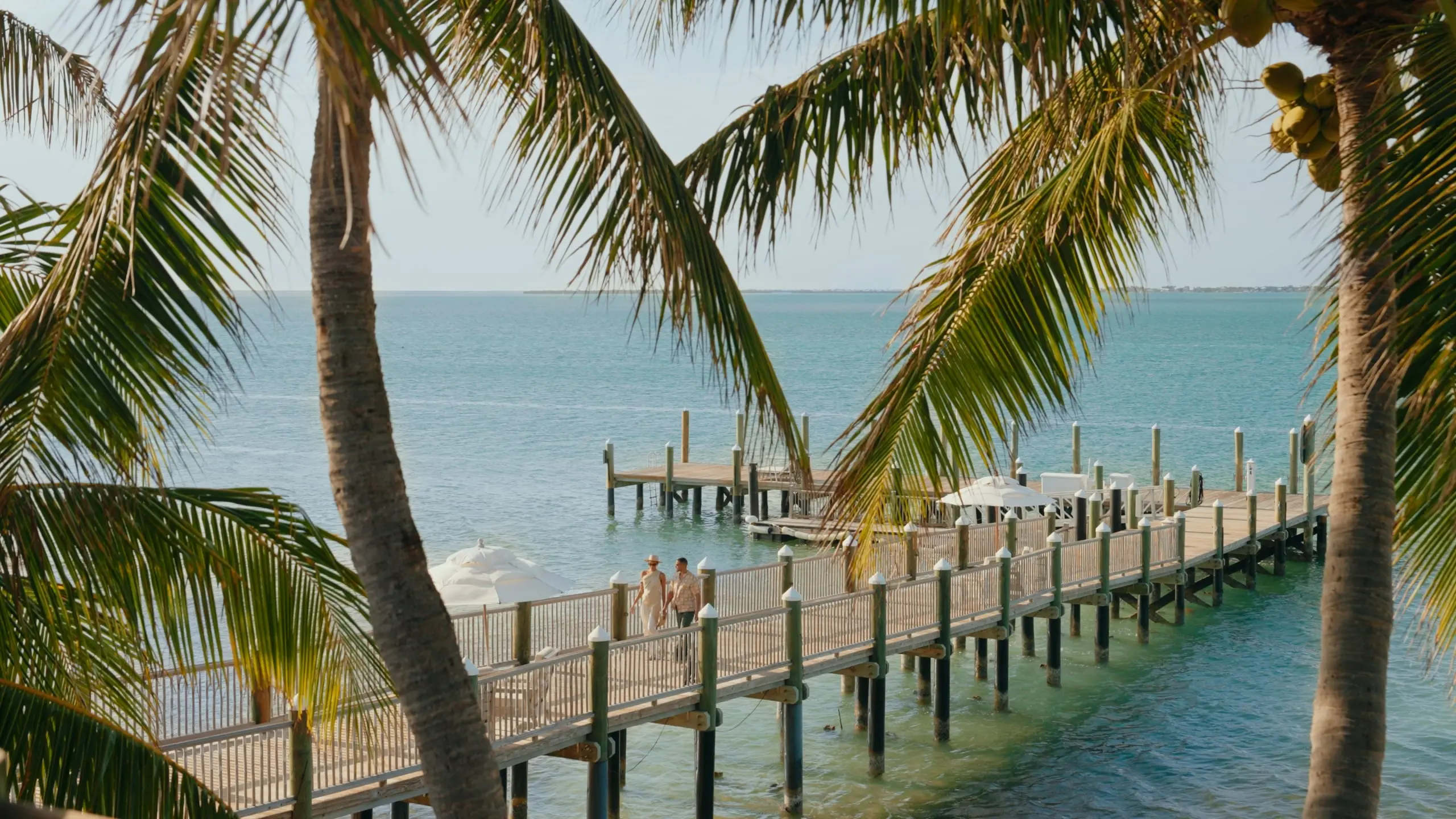 A couple walking hand in hand along the pier at Little Palm Island Resort