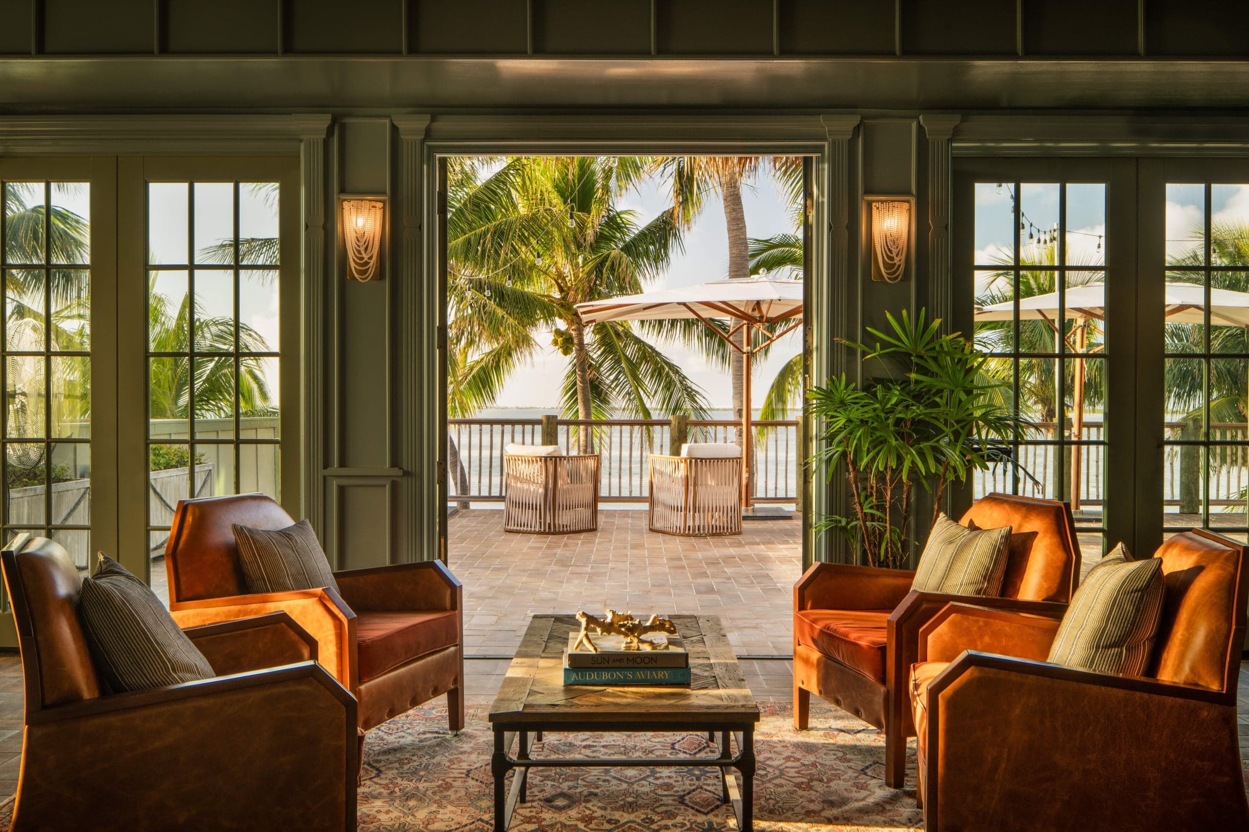 A seating area at Little Palm Island Resort with open doors to a furnished oceanfront terrace.