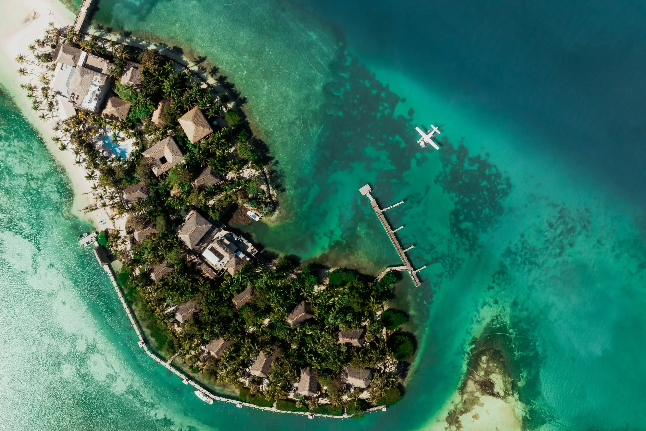 An aerial view of Little Palm Island Resort with a seaplane arriving at the private marina.