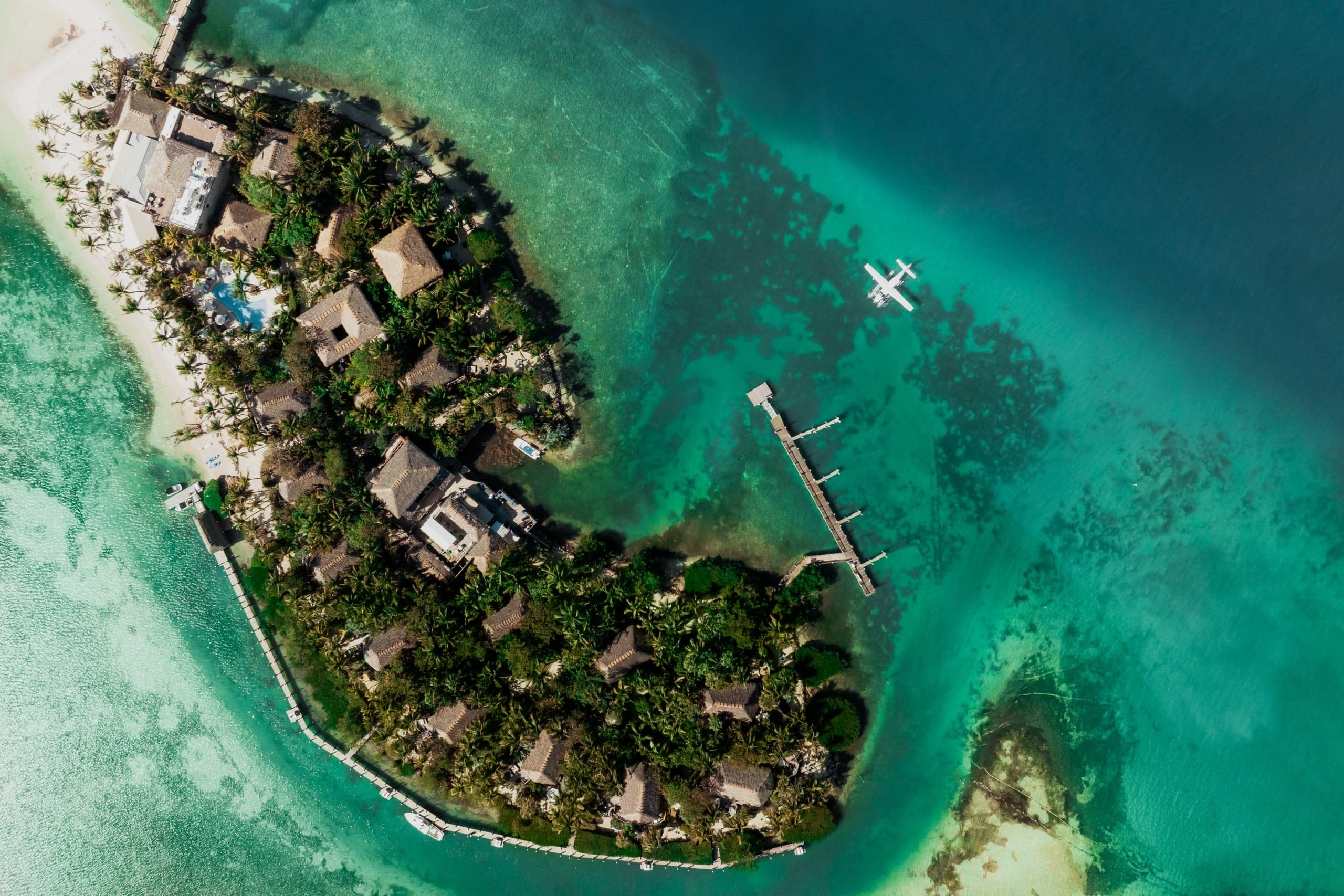 An aerial view of Little Palm Island Resort with a seaplane arriving at the private marina.