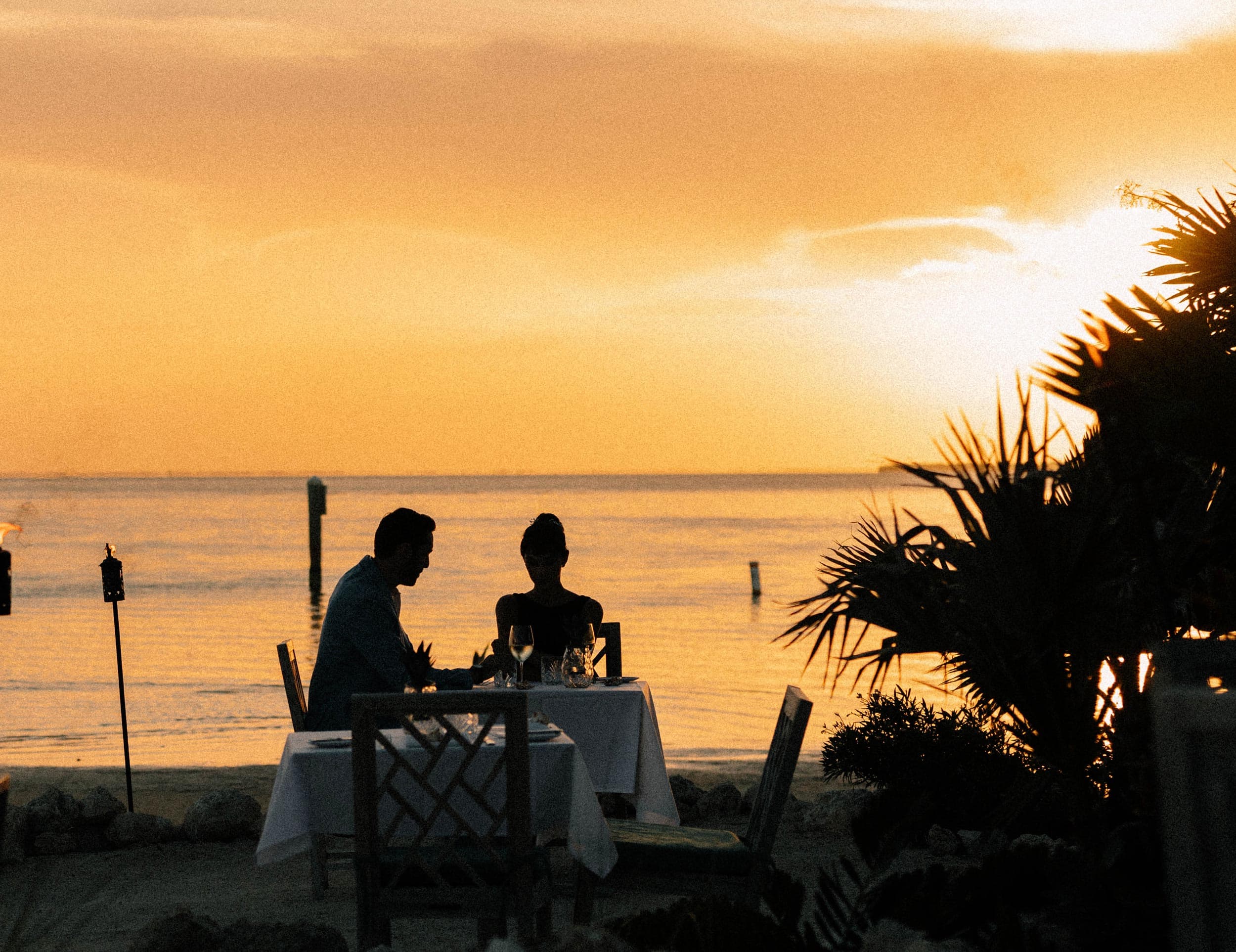 Couple Dining On The Beach At Sunset
